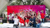 Karyawan Indosat Ooredoo Hutchison berpose bersama dalam acara People Fest HUT RI dengan latar panggung merah bertema kemerdekaan.