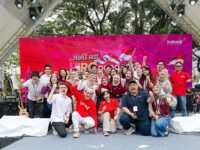 Karyawan Indosat Ooredoo Hutchison berpose bersama dalam acara People Fest HUT RI dengan latar panggung merah bertema kemerdekaan.